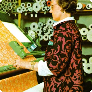 Rococo työntakissa tehdasesitteessä 1975. Kuvassa Aini Vesanen tarkastaa painatusta.